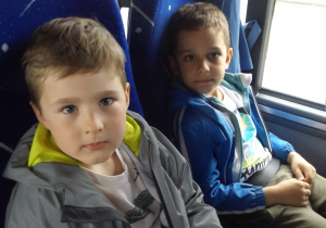 dwóch chłopców siedzi obok siebie w autokarze